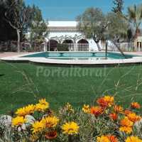 Piscina y casa al fondo